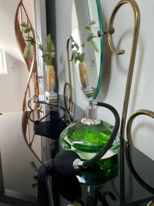 a green lamp with a mirror on a shelf at Maison de la Calonne - Riverside house & terrace in Cormeilles