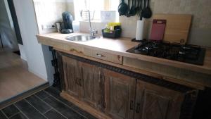 a kitchen counter with a sink and a stove at Le Petit Soleil in Isserpent