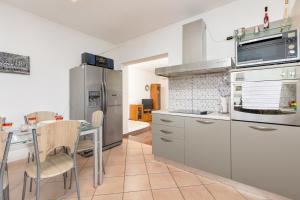 a kitchen with a table and a stainless steel refrigerator at Villa Laura in Vantačići