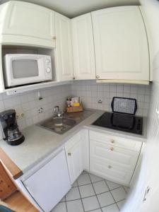 una pequeña cocina con fregadero y microondas en Sylvie-Steinhardt-Wohnung-4 en List