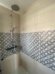 y baño con ducha y azulejos en la pared. en Sylvie-Steinhardt-Wohnung-4 en List