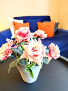 um vaso cheio de rosas rosas e amarelas sobre uma mesa em Mimi's place/ Уют в центъра на София em Sófia