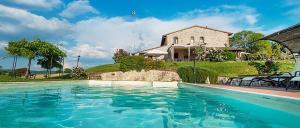 a large swimming pool in front of a house at Agriturismo Gattogiallo in Montegabbione