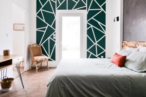 ein Schlafzimmer mit einem Bett mit einer grünen Wand in der Unterkunft Superbe maison de vacances entre plage et marais - 7 pers in Brem Sur Mer