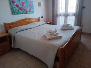 a bedroom with a bed with two towels on it at RESIDENCE CERRA in Otranto +3 photos