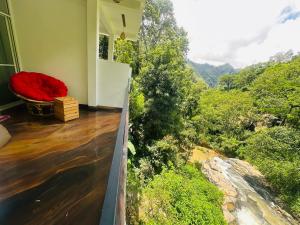 a room with a red bed and a view of the forest at River Splendour Home Stay in Ella