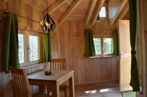 a dining room with a table and chairs in a cabin at Baumhaushotel Solling in Uslar