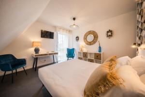 ein Schlafzimmer mit einem Bett, einem Schreibtisch und einem Stuhl in der Unterkunft Hôtel de la Brière et Restaurant Les Krapados in Saint-Lyphard