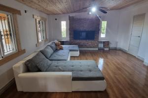 uma sala de estar com um sofá e uma televisão em Chalet Montes de Llanorel em Valência
