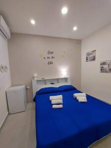 Un dormitorio con una cama azul con toallas. en NapoliDream Bed and Breakfast, en Nápoles