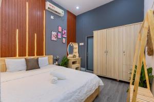 1 dormitorio con cama blanca y espejo en Victory Villa 13 - Đi Bộ Ra Biển Bãi Sau en Vung Tau