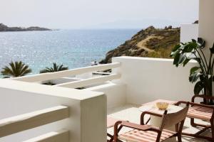 a balcony with chairs and a table and the ocean at Nammos Hotel Mykonos in Psarou