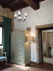 MonteorselloにあるAgriturismo Casa Rastelliの大きなキャビネットとランプ付きの部屋