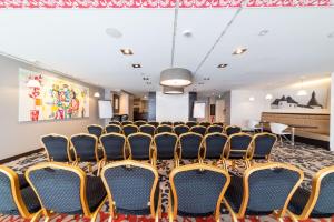 sala konferencyjna z krzesłami i pianinem w obiekcie Le Clervaux Boutique Hotel & Spa w mieście Clervaux