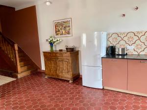 a kitchen with a white refrigerator and a table at Gîte de la maison jaune - Comblanchien in Comblanchien +22 photos