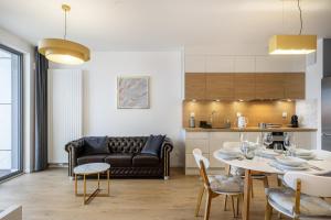 ein Wohnzimmer mit einem Tisch und einem Sofa in der Unterkunft 04 Gdynia Premium - Apartament Mieszkanie dla 2 osób z parkingiem in Gdynia