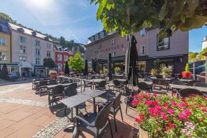an outdoor cafe with tables and chairs and flowers at Le Clervaux Boutique Hotel & Spa in Clervaux