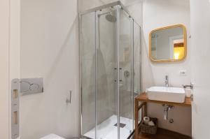 a bathroom with a glass shower and a sink at Youhosty - Ticinese Suite 2 in Milan +9 photos