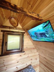 TV en la esquina de una cabaña de madera en Cottage 1600 Bosaca en Nikšić