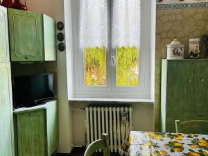 a kitchen with green cabinets and a table and a window at Ma'Già 2 in Fresonara