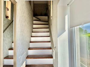 - un escalier dans une maison dotée de murs blancs et de parquet dans l'établissement Country Haven Comfy & Sleek Apartment, à Kildare