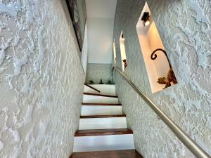 - un escalier dans une maison aux murs blancs dans l'établissement Country Haven Comfy & Sleek Apartment, à Kildare