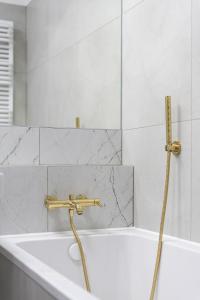 a bathroom with a bath tub with a gold faucet at 04 Gdynia Premium - Apartament Mieszkanie dla 2 osób z parkingiem in Gdynia