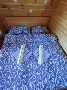 a bed in a room with two pillows on it at Cottage 1600 Bosaca in Nikšić