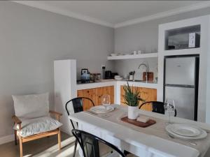 a dining room with a white table and chairs at Hartshuijs in Beaufort West