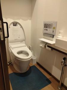 a bathroom with a toilet and a blue rug at 秋桜館Cosmos in Kyoto
