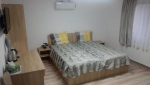 Habitación pequeña con cama y escritorio. en Casa Sofia, en Târgu Jiu