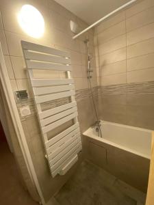 a bathroom with a bath tub and a sink at Le Chalain cosy proche centre ville in Les Rousses +24 photos