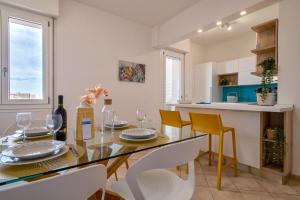 サッサリにあるSARDINIA RE - Emerald Houseのダイニングルーム(ガラステーブル、黄色の椅子付)