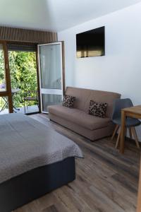 ein Schlafzimmer mit einem Bett, einem Sofa und einem Tisch in der Unterkunft Hotel Restaurant Moselblick in Wintrich