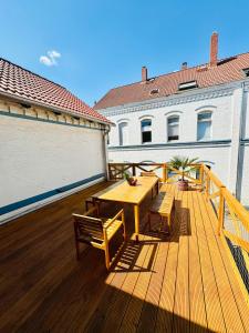 a wooden deck with a wooden table and benches at Zentrales Apartment mit großer Terrasse in Braunschweig