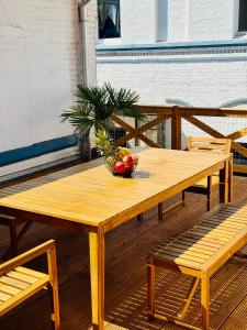 a wooden table with a bowl of fruit on a deck at Zentrales Apartment mit großer Terrasse in Braunschweig
