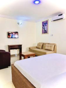 ein Hotelzimmer mit einem Bett und einem Sofa in der Unterkunft Vintage Classic Lodge in Lagos