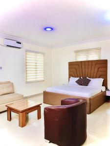 um quarto com uma cama, uma cadeira e uma mesa em Vintage Classic Lodge em Lagos