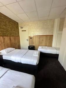 een slaapkamer met 3 bedden en een hal met een deur bij Flex-Inn in Rotterdam