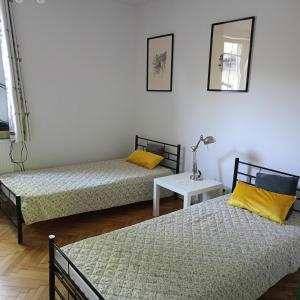 Zimmer mit 2 Betten, einem Tisch und einem Spiegel in der Unterkunft Augustówka - letnisko na Wrzosowiskach 