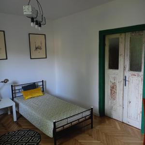 ein Schlafzimmer mit einem Bett in einem Zimmer mit einer Tür in der Unterkunft Augustówka - letnisko na Wrzosowiskach 