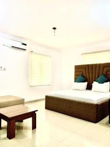 a bedroom with a large bed and a table at Vintage Classic Lodge in Lagos
