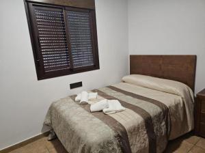 1 dormitorio con 1 cama con 2 toallas en Casa piscina, en Chiclana de la Frontera