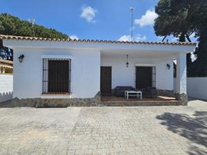 una casa blanca con un sofá delante en Casa piscina, en Chiclana de la Frontera