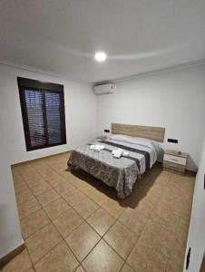 1 dormitorio con 1 cama en una habitación con ventana en Casa piscina, en Chiclana de la Frontera