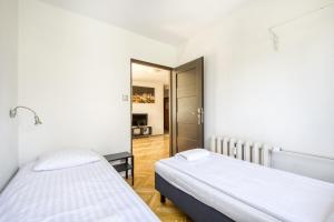two beds in a small room with a hallway at Labo Apartment Panska in Warsaw