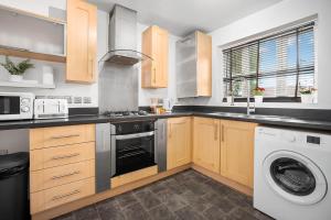 uma cozinha com um fogão e uma máquina de lavar roupa em 2 Bedroom House - Garden & Parking 2GM - Wifi em Birmingham