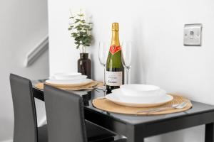 a dining room table with a bottle of wine and plates at 2 Bedroom House - Garden & Parking 2GM - Wifi in Birmingham