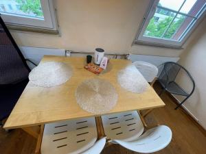 Heimsheim的住宿－L8 Street - Heimsheim，一张带四把椅子的木桌和一张带两个圆盘的桌子