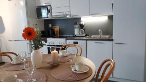a kitchen with a wooden table with a vase of flowers at Lomayksiö C 3 Sotkamon keskustassa in Sotkamo